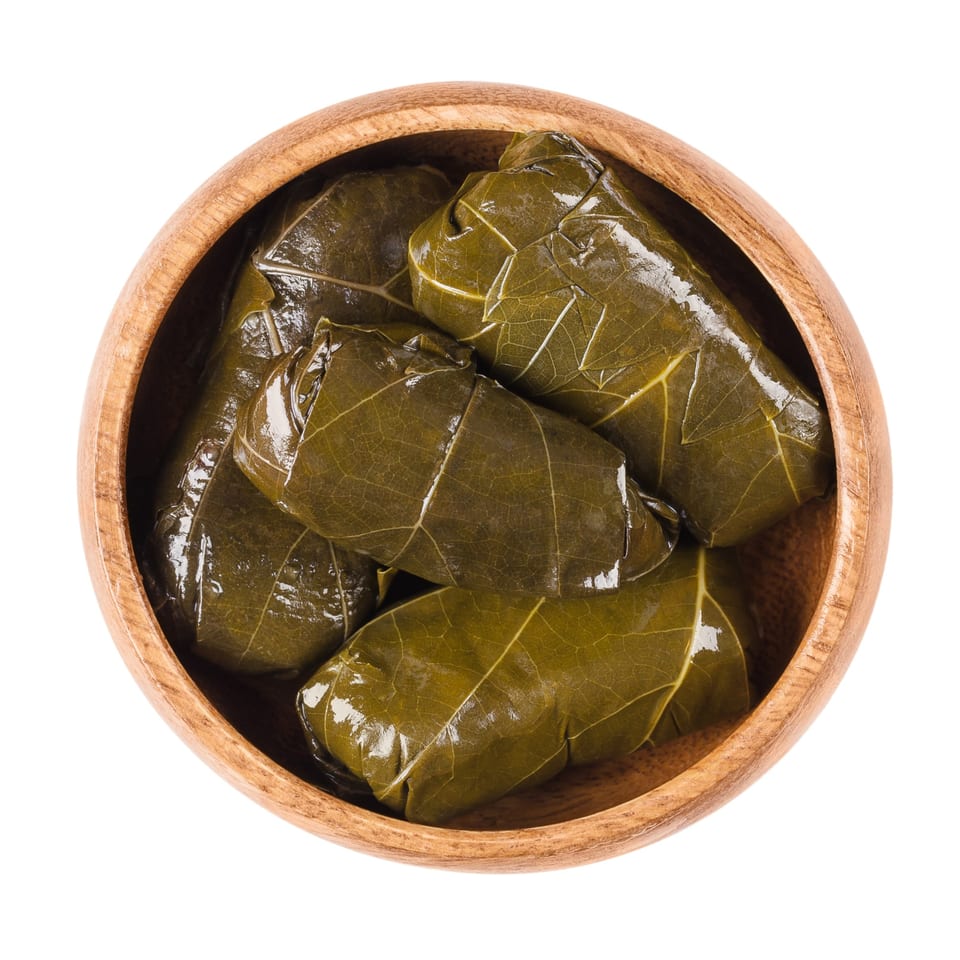 Casba Food and Pastries' middle-eastern dolmades, or stuffed grape leaves, in a wooden bowl.